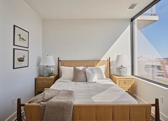 A bedroom with a large bed and a view of the city.