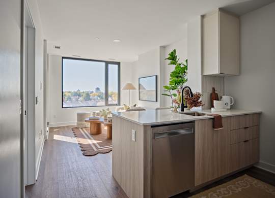 A modern kitchen with a large window overlooking the outdoors.