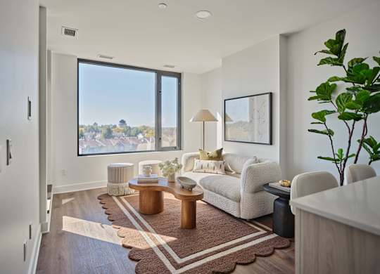 A living room with a large window overlooking a cityscape.