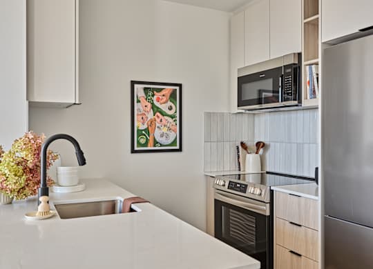 A kitchen with a sink, stove, and refrigerator.