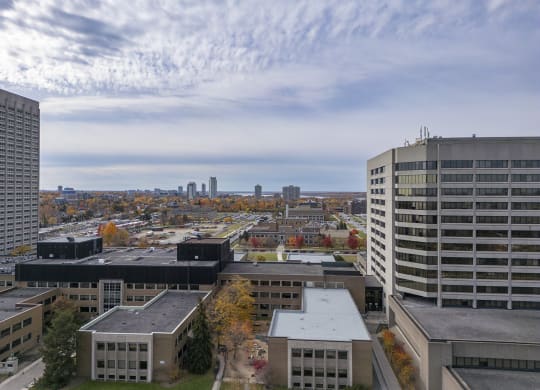 an aerial view of the city with buildings and a blue cloudy sky