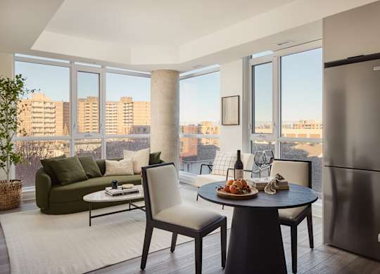 A modern kitchen with a table set for two and a view of the city.