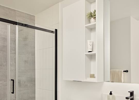 A white toilet sits next to a sink in a modern bathroom.