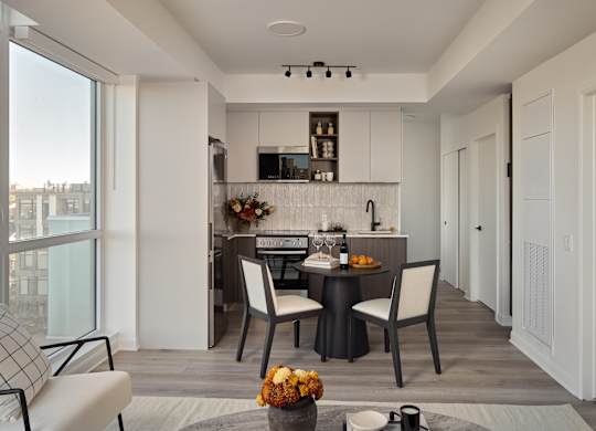 A modern kitchen with a dining table set for two.