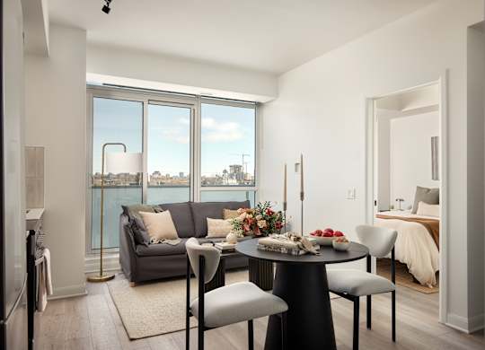 A modern dining room with a table set for four and a view of the city.