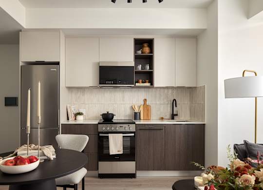 A modern kitchen with a refrigerator, oven, and sink.