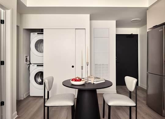 A modern kitchen with a table set for two.