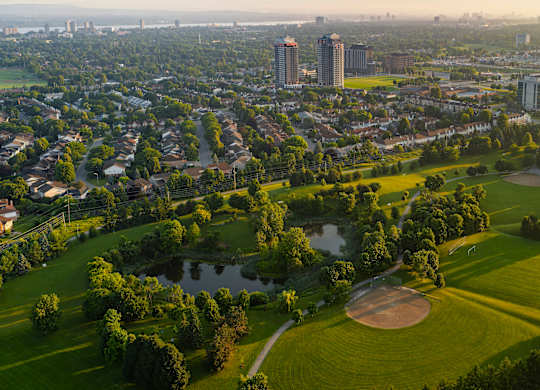 A golf course is surrounded by a city.
