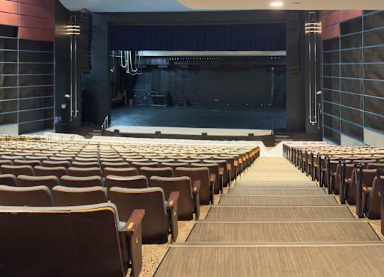 A large auditorium with rows of seats facing a stage.