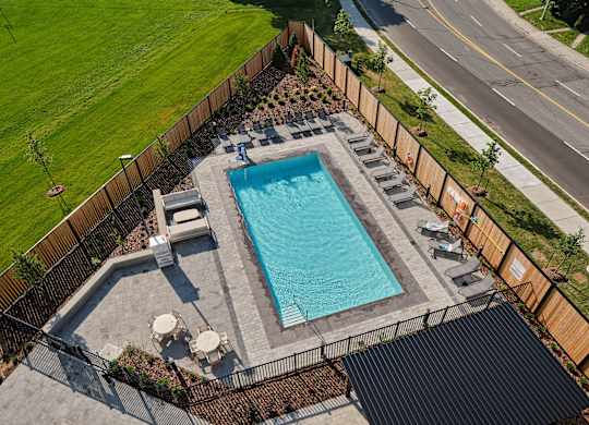 A small rectangular pool surrounded by a fence and a black roof.
