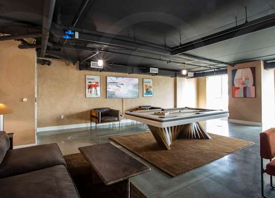 Recreation room with pool table and lounge seating at Crenshaw Lofts Apartments, Los Angeles, 90043
