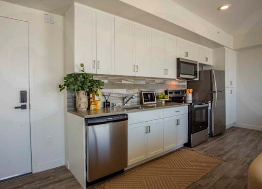 A modern kitchen with white cabinets and stainless steel appliances.
