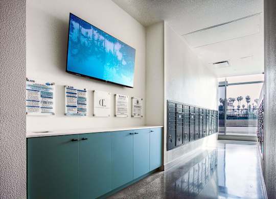 A hallway with a row of lockers and a TV mounted on the wall.