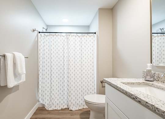 Spacious bathroom with patterned shower curtain at Windham Village Apartments, Windham, 04062