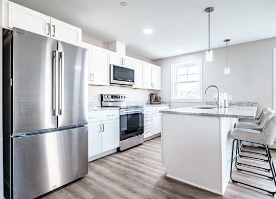 Modern kitchen with white cabinetry and granite countertops at Windham Village Apartments, Windham, Maine