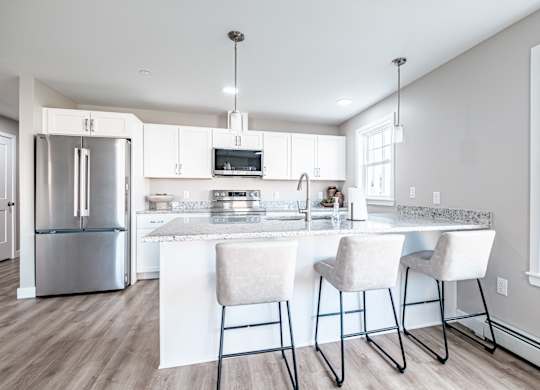 Modern kitchen with granite island and bar seating at Windham Village Apartments, Windham
