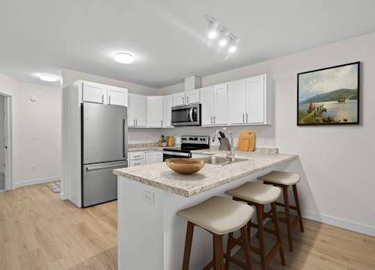 A kitchen with white cabinets and a granite countertop.