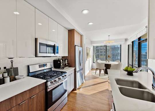 A modern kitchen with a stove, sink, and refrigerator at Chateau on Wells, Illinois, 60654