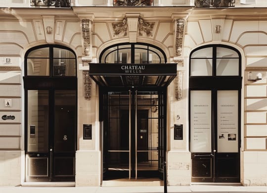 the facade of a building with two black doors at Chateau on Wells, Chicago, IL