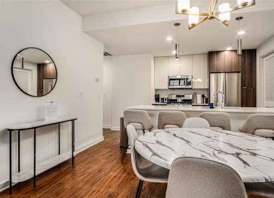 A modern kitchen with a marble table and chairs.
