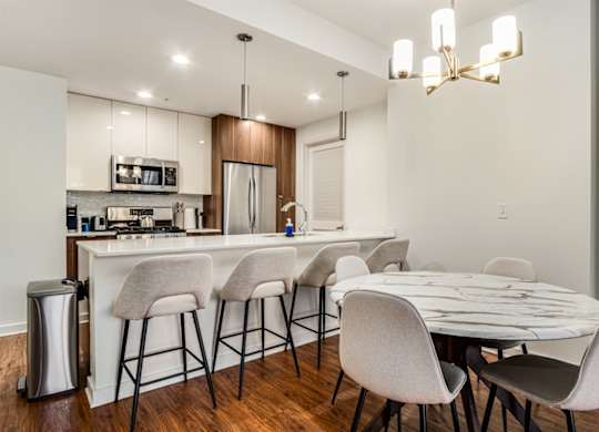 A modern kitchen with a bar area and a dining table set up.