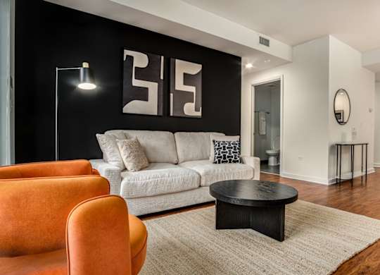 A living room with a white couch, a black coffee table, and a floor lamp.