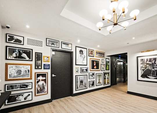 A hallway with a chandelier and pictures on the wall at Chateau on Wells, Chicago, 60654