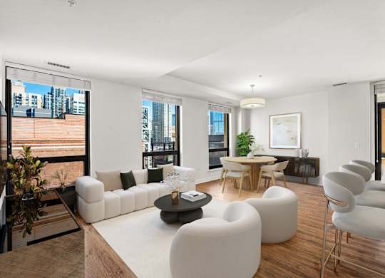 A modern living room with white furniture and a large window overlooking the city at Chateau on Wells, Illinois
