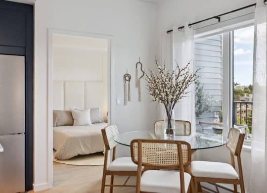 a bedroom with a bed and a dining room with a table and chairs