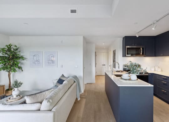a kitchen and living room with a white couch and a counter