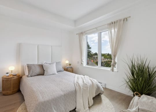 a white bedroom with a bed and a window