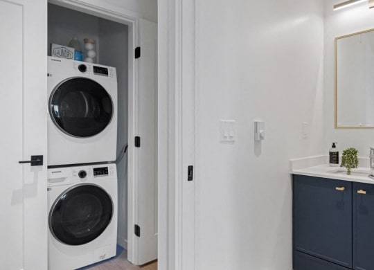 a small laundry room with a washing machine and a sink