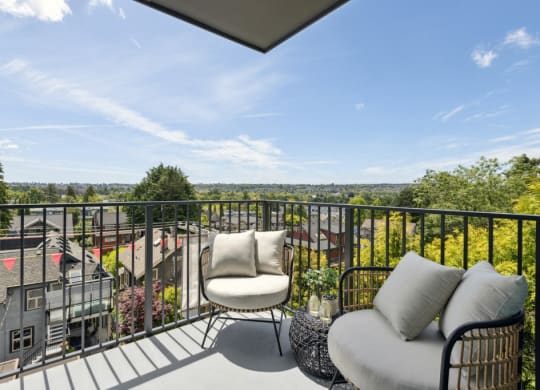 a balcony with two chairs and a view of a city