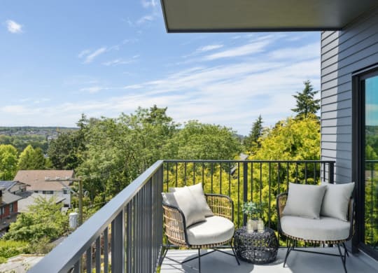 a balcony with two chairs and a view of the city