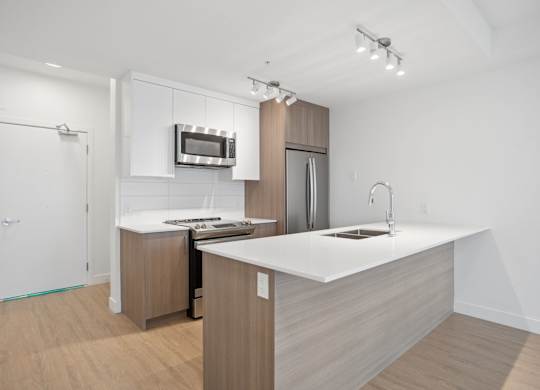 A modern kitchen with a white countertop and wooden cabinets.