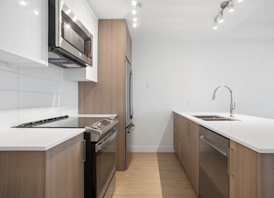 A modern kitchen with wooden cabinets and stainless steel appliances.