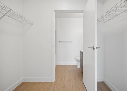 A white bathroom with a toilet and a door.