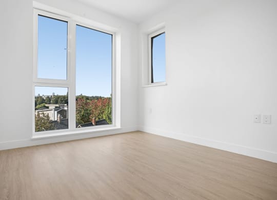 A room with a view of a residential area through the windows.