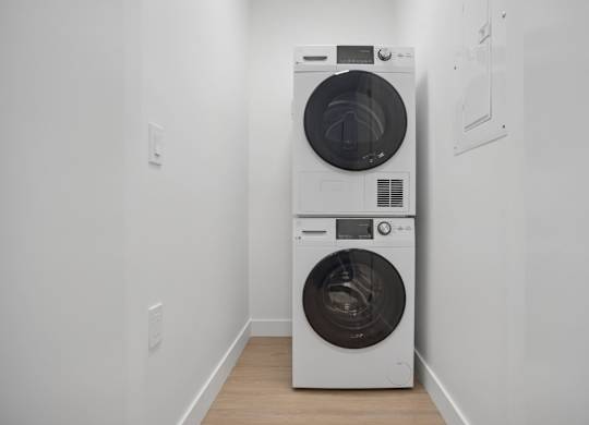 A white washing machine and dryer in a small room.
