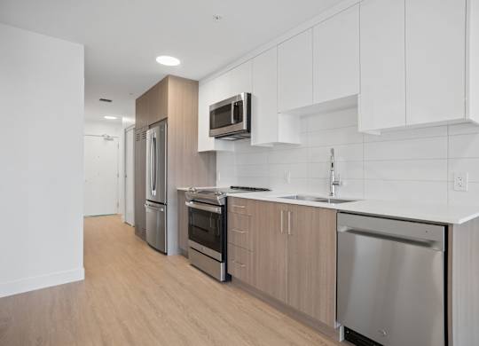 A modern kitchen with stainless steel appliances and wooden cabinets.