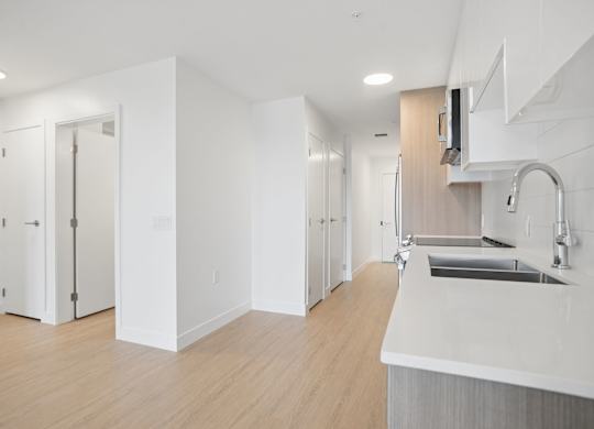 A modern kitchen with white cabinets and a white countertop.