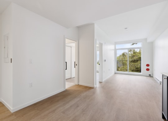 an empty living room with white walls and wood floors
