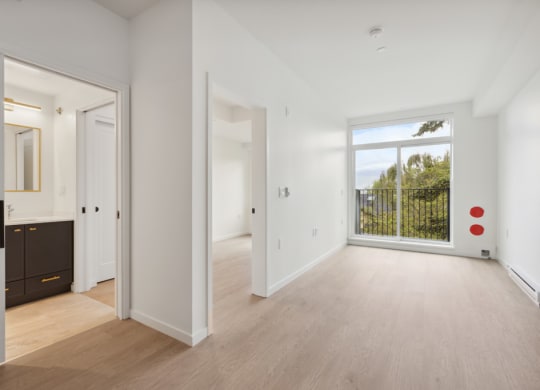 a living room with a large window and a door to a bedroom