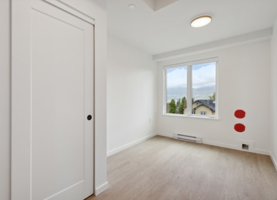 an empty room with white walls and a window