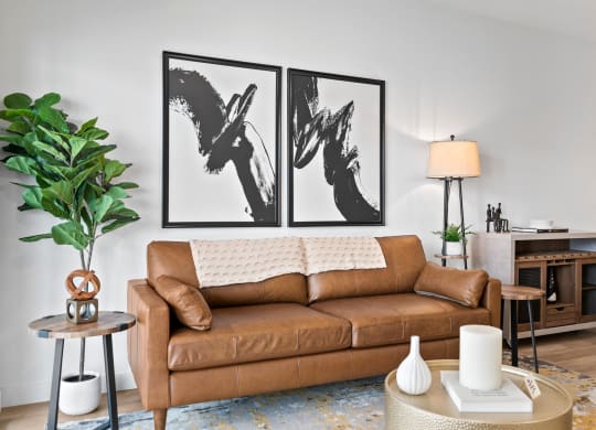 a living room with a couch and two paintings on the wall