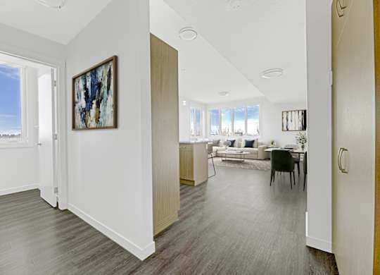 A living room with a grey floor and a painting on the wall.