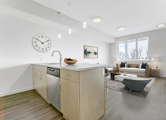 A modern kitchen with a large island and a clock on the wall.