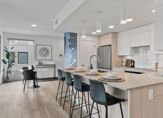 a kitchen with an island and stools in a 555 waverly unit