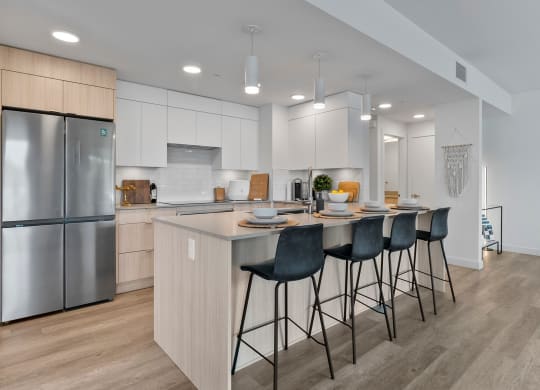 a kitchen with white cabinets and a large island with a breakfast bar