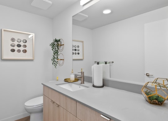 a bathroom with white walls and a white vanity with a white sink and toilet